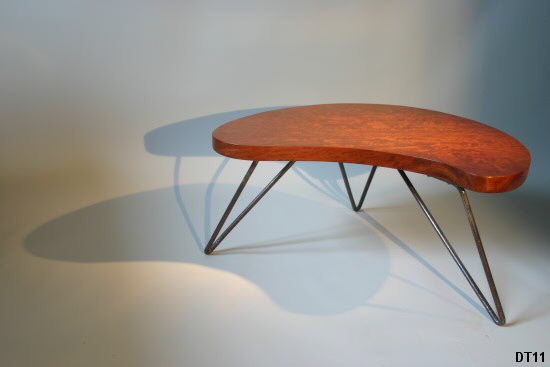 Petite table basse, vers 1950; pitement en fer cintr laqu noir, pais plateau de bois exotique. Dans le got de Jean Royre.