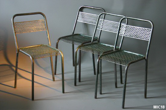 Série de 4 chaises tubulaires, assise et dossier métal ajouré. Intéressant jeu de transparence pour ces chaises en acier.