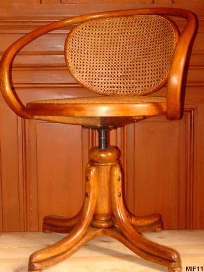Fauteuil en bois courb THONET vers 1930, pied perroquet, pivotant , rglable en hauteur, htre cir, cannage neuf.