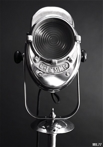 Projecteur de cinéma de marque « CREMER », vers 1940, puissance de 250 Watts, pied tripode, hauteur réglable, bouton latéral en bakélite. Acier poli, aluminium et lentille Fresnel.