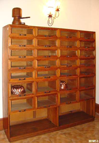 Meuble de mtier vers 1940, origine anglaise, compos de 28 tiroirs vitrs et de deux tagres basses, chne massif, lgrement crus, poignes laiton