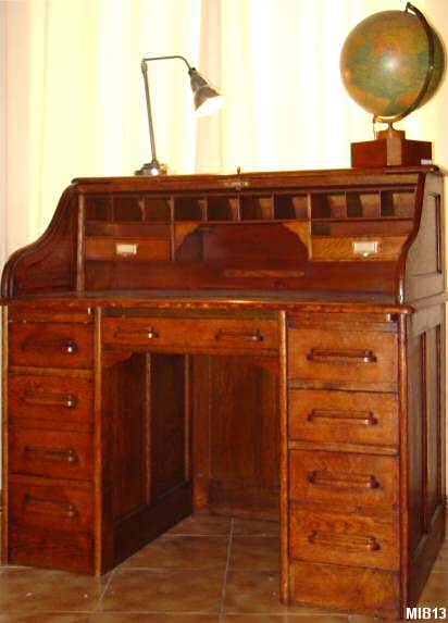 Bureau  cylindre de type dos d'ne vers 1930, rideau coulissant, 9 tiroirs, 2 tablettes 2 tiroirs interne, nombreuses tagres. Corps chne massif. Poignes bois