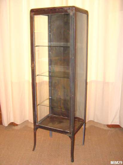 Petite armoire de médecine vers 1920, jolis pieds, comprenant une porte et trois étagères en verre, métal brut.