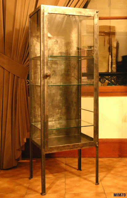 Petite armoire de médecine vers 1920, jolis pieds, comprenant une porte et trois étagères en verre, métal brut.